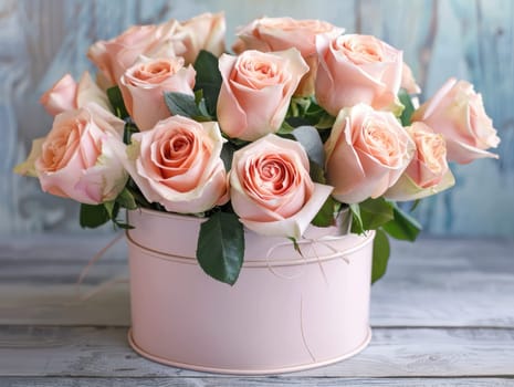 The delicate bouquet showcases vibrant pale pink roses surrounded by lush green leaves, elegantly placed in a soft pink container on a weathered wooden surface.