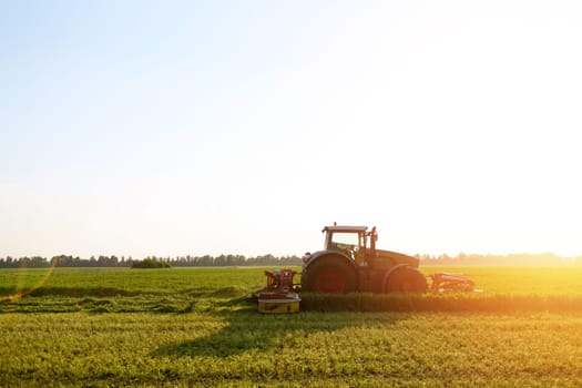 hay making for animals, harvesting green grass for feed with a tractor, agribusiness concept, animal feed