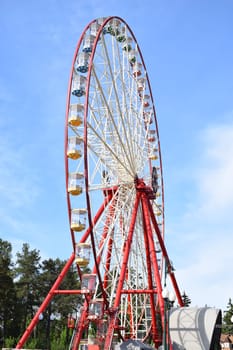 Ferris wheel against the blue sky in the city park with copy space.