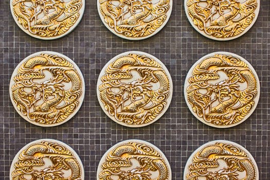 Image of Close up of three golden dragon coins on black tile background