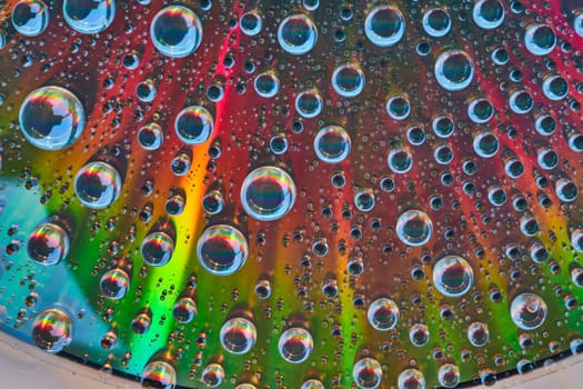 Image of Abstract metallic surface with brilliant colors and water drops on top with mini rainbows