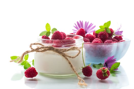 Sweet prepared homemade yogurt with fresh raspberries in a glass jar, isolated on white background.