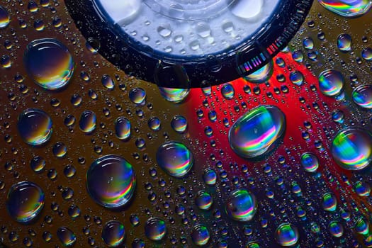 Image of Dark silvery water drops on abstract CD surface with rainbow colors background asset