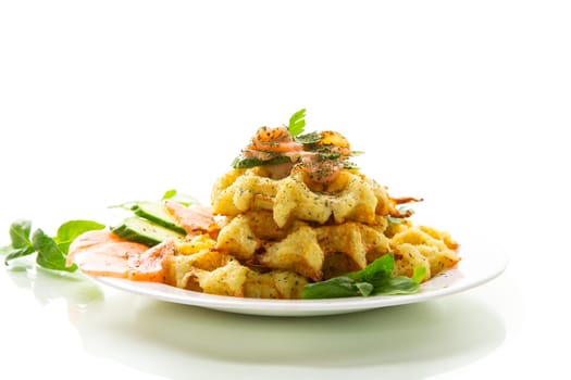 Cooked potato waffles with lightly salted red fish and herbs in a plate, isolated on white background .