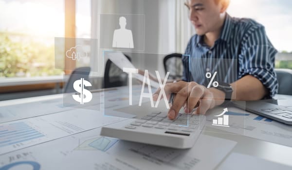 Close up Businessman using calculator and laptop for do math finance on wooden desk in office and business working background, tax, accounting, statistics and analytic research concept.