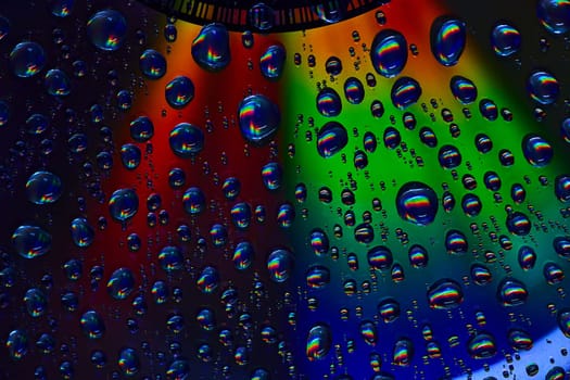 Image of Dark and colorful metallic surface with rainbow bubbles on abstract CD surface in background asset