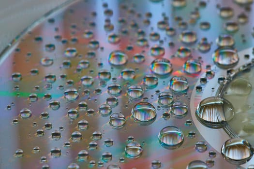 Image of Side view of rainbow water drops in macro view of metallic surface abstract background asset