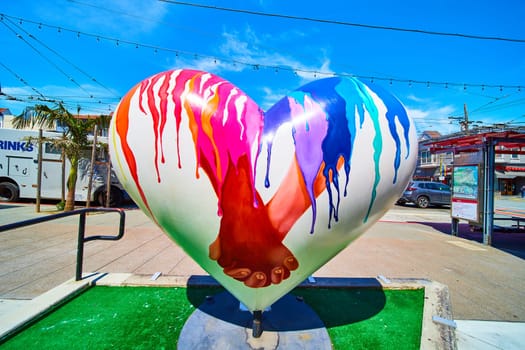 Image of Sculpture in Castro District of heart with people holding hands on bright sunny day