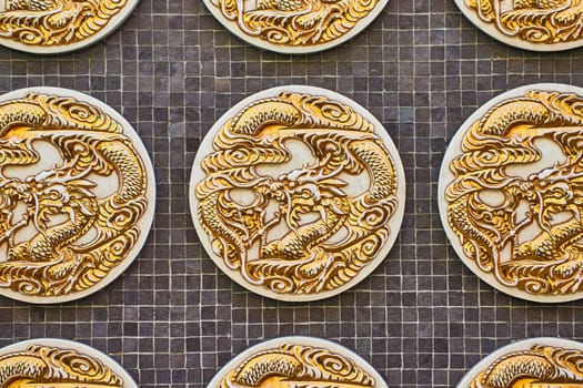 Image of Detailed view of a golden Chinese dragon coin on black tile background