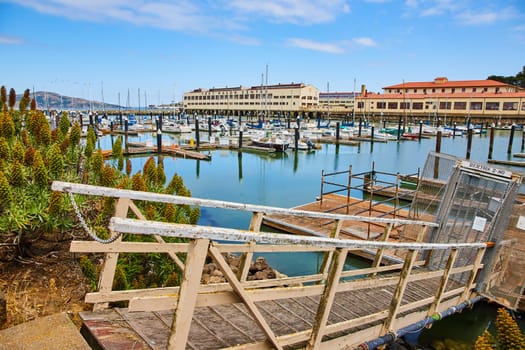 Image of Fort Mason Center small ramp leading to docks with boats on tranquil waters in the morning