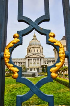 Image of City hall and memorial court viewed through fancy black and golden gilded lamppost