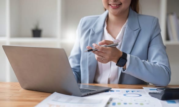 Asian businesswoman use laptop computer in office The Internal Revenue Service audit document balance calculation report is being prepared..