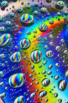 Image of Silvery swirling water drops in cosmic rainbow Saturn ring in psychedelic background asset