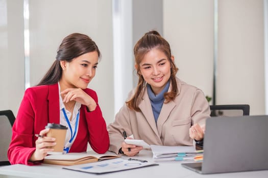 Two business women are discussing and exchanging knowledge on graphs and finance data..