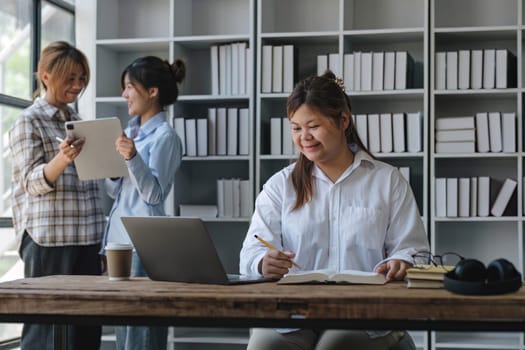 College students using laptop while sitting at table. Group study for school assignment