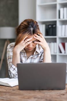 Portrait of frustrated worried young Asian girl looks at laptop upset by bad news, negative bullying message, troubled with problem online or email notification...