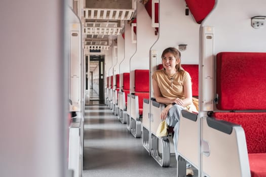 Beautiful girl with a backpack sitting in the train. Traveling, journey..