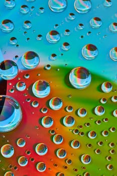 Image of Abstract background asset of large to small water droplets on green and red surface with blue arc