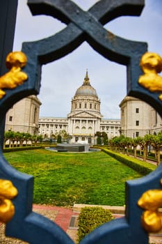 Image of Framed view of memorial in courtyard and city hall through black and golden gilded lamppost