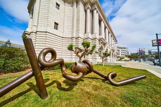 Image of Abstract bronze tubes creating art sculpture near government building in San Francisco