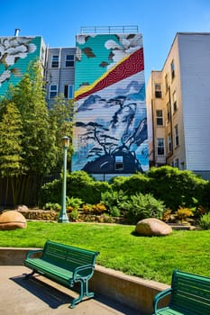 Image of Zen park with peaceful art mural on buildings with green benches