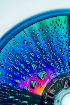 Image of Gorgeous blue and green with burst of pink and orange on metallic surface with water drops