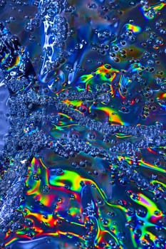 Image of Oily surface with rainbow burst of color and streams of bubbles in abstract background asset