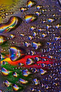 Image of Burst of fizzy soda bubbles with metallic surface and rainbow colors in dark background asset