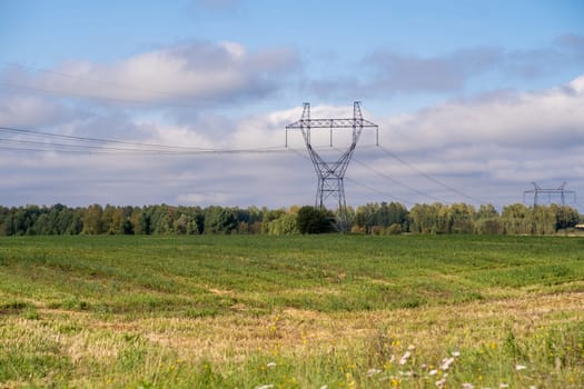 Metal poles electric supports for high-voltage wires in the fields in the summer.High Voltage Poles or Electric tower is transmission high voltage power locate on green field Energy technology concept