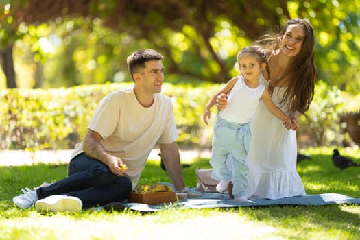 Family having a picnic and having fun in the park. Mid shot