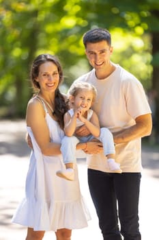 Smiling happy family in the park. Vertical shot