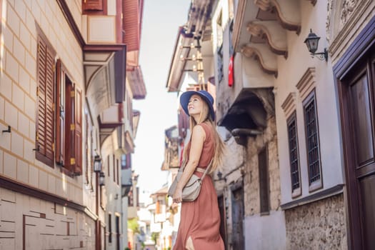 Happy woman tourist on background of old street of Antalya. female tourist traveler discover interesting places and popular attractions and walks in the old city Kalechi of Antalya, Turkey. Turkiye.