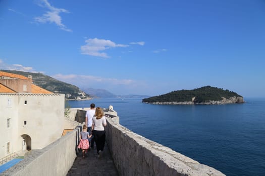 Dubrovnik, Croatia, old town, tiled roof of a house ancient stone building with a triangular facade, top view, people tourists walking April 22, 2023. High quality photo