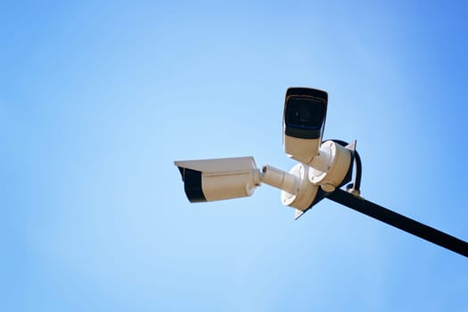 A stunning and striking view of modern surveillance cameras positioned perfectly under a clear blue sky