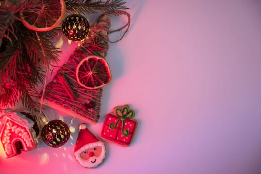 Christmas holiday neon color background with fir branches, toys garland and decorations. Xmas and Happy New Year theme. Flat lay, top view, space for text