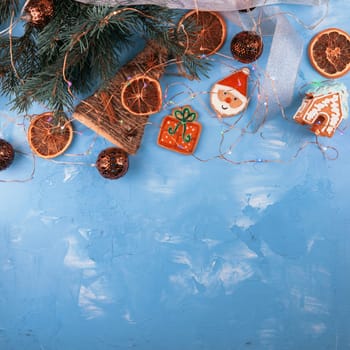 Ney year 2021 holiday blue concrete background with fir branches, toys garland and decorations. Xmas and Happy New Year theme. Flat lay, top view, space for text