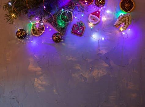 Christmas holiday blue concrete background with fir branches, toys garland and decorations. Xmas and Happy New Year theme. Flat lay, top view, space for text