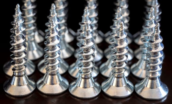 Close up of screws on a black background. Advertising photo
