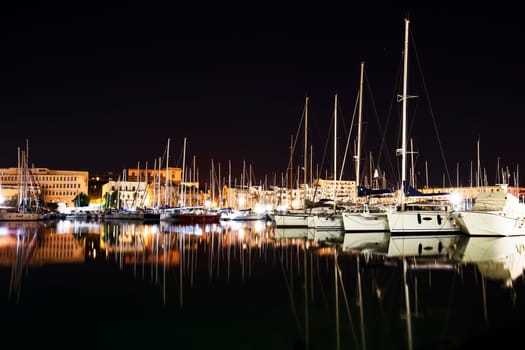 Moored boats and yachts at night in a harbor in Palermo, Sicily