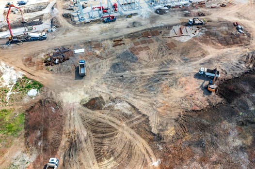 Aerial top view of big construction site with many working heavy machines
