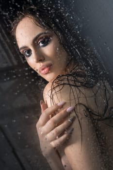 Nude beautiful brunette relaxing in shower her hair loose and wet