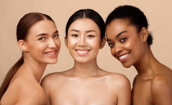 Three Gorgeous Girls Models Posing Naked Smiling To Camera Standing Over Gray Studio Background. Beauty And Body Care Concept
