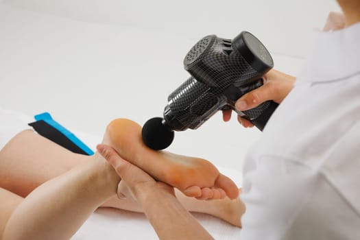 massage therapist uses vibration massage tool, Self Massage Tools, Massage gun, handheld electric massager for deep tissue and body muscles,