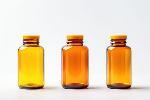 Three amber glass bottles with yellow caps on white background. Medicine, pharmacy, and healthcare concept.