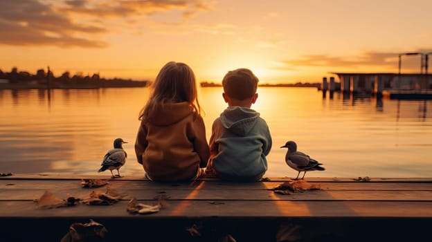 Two children watching sunset over lake with birds. Childhood, friendship, nature concept.