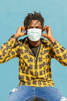 vertical photo of an attractive young black man wearing a protective mask, lifestyle concept and virus protection