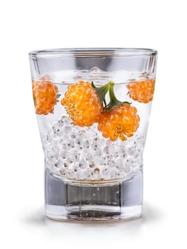 Finnish Cloudberry Liqueur in shot glass garnished with few fresh cloudberries. Drink isolated on transparent background.