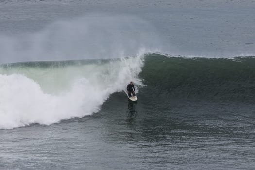 TORQUAY, AUSTRALIA - MAY 28 2023: A surfer tackles huge swell at Pt Addis near Torquay, Victoria, Australia