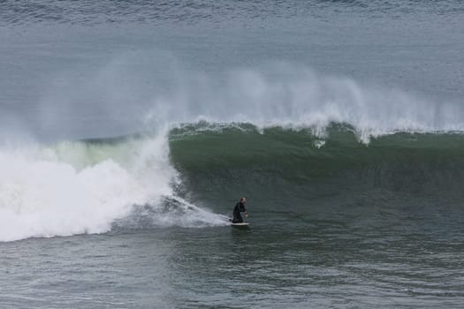 TORQUAY, AUSTRALIA - MAY 28 2023: A surfer tackles huge swell at Pt Addis near Torquay, Victoria, Australia