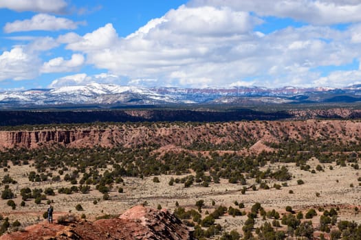 Explore the breathtaking landscape of Utah's Kodachrome Basin State Park, featuring a vast desert terrain with a snowy Bryce Canyon National Park in the background - USA